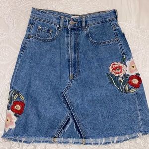 Denim mini skirt with embroidered flowers.